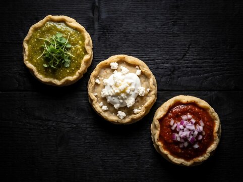 Mexican Independence Day sopes in flag colors on dark wood desk