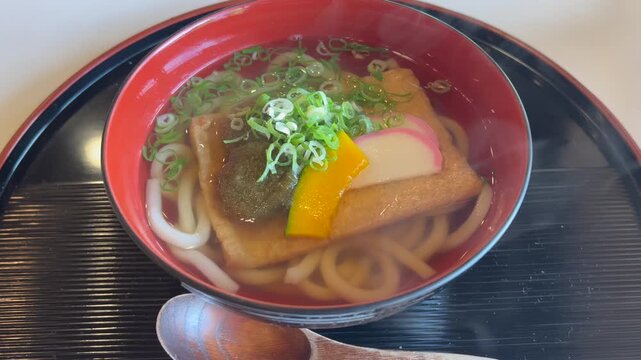 湯気立つ美味しそうな温かいうどんのランチ