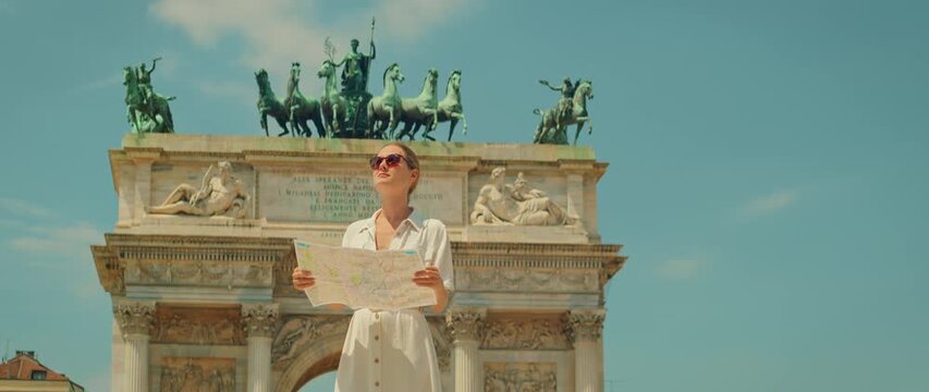 Tourist standing in front of Arco della Pace in Milan city on a sunny day, Italy