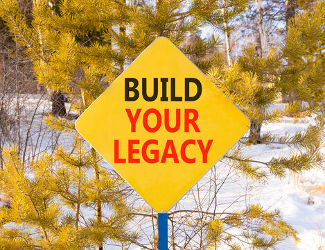 Build your legacy words symbol. Concept words Build your legacy on beautiful yellow road sign. Beautiful winter forest background. Business build your legacy concept. Copy space.