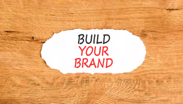 Build your brand words symbol. Concept words Build your brand on beautiful white paper. Beautiful wooden background. Business and build your brand concept. Copy space.