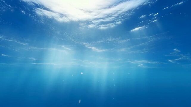 Sunlight rays penetrate the water surface with drifting particles in a clear underwater ocean environment. Drifting particles creates light diffusion and visible depth.