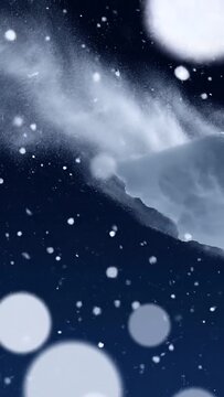 Snow blowing off a snow covered ridge against a deep navy night sky, vertical winter footage