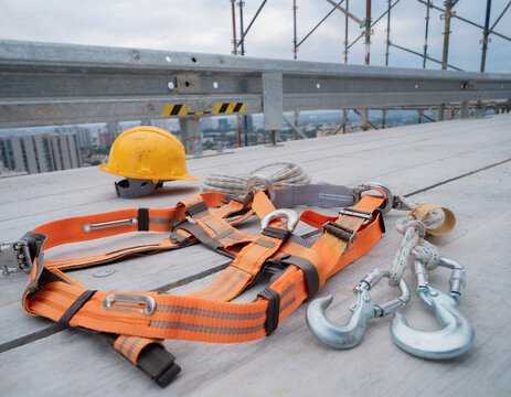 Full-body fall protection harness with safety belt, hooks and lifeline equipment arranged on a construction platform, working at height, occupational safety, fall prevention