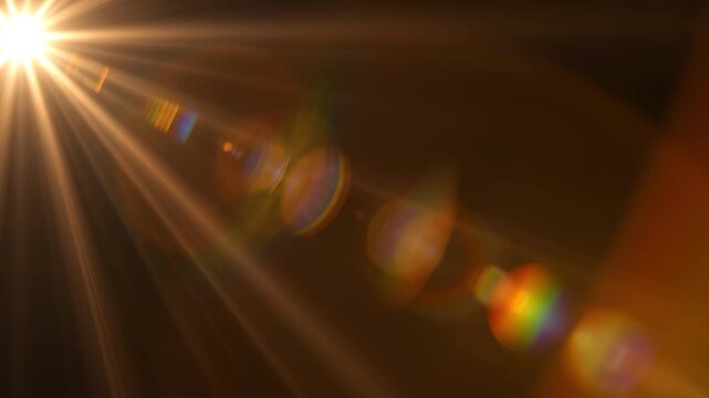 Golden sun flare light streaks with bokeh orbs emerging from bright lens effect during golden hour