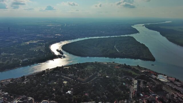 Aerial view of Belgrade at confluence of Sava and Danube rivers. Urban landscape, forested river island and city panorama, 4k