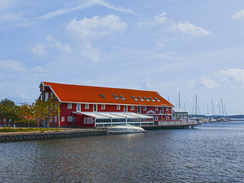 KRISTIANSAND, NORWAY - AUGUST 9, 2026: Sj&oslash;huset Restaurant in a traditional red waterfront building beside a marina with boats and sailboats in central Kristiansand.
