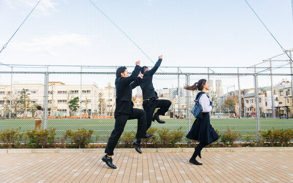 Japanese students meeting outdoors  - Young asian friends wearing college uniform bonding in Tokyo