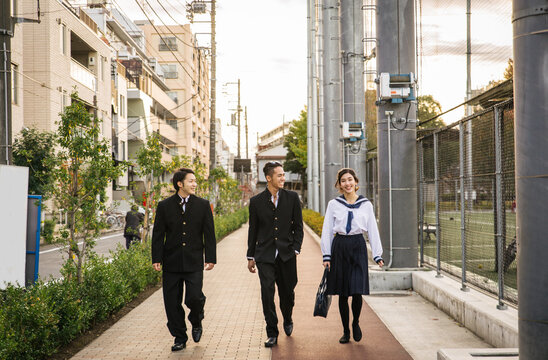 Japanese students meeting outdoors  - Young asian friends wearing college uniform bonding in Tokyo