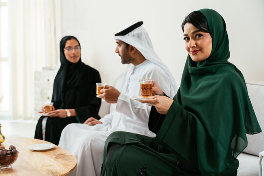 Emirati friends enjoying tea and conversation in living room