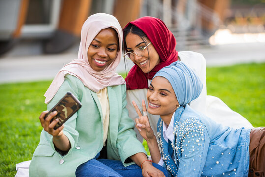 Beautiful muslim girl wearing hijab bonding outdoors