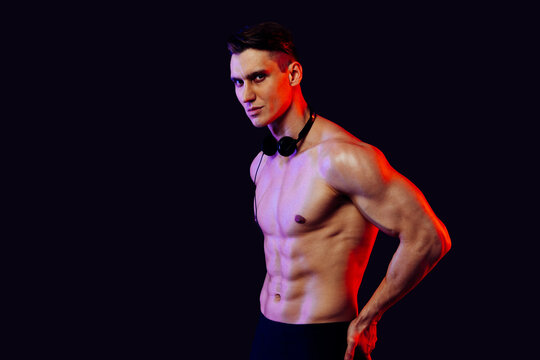 Athletic man with fit muscular body training in studio