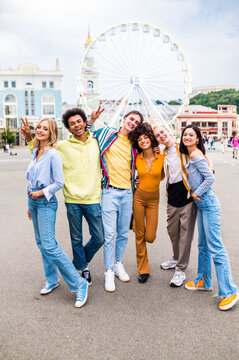 Multiracial young people together meeting and social gathering - Group of friends with mixed races having fun outdoors in the city- Friendship and lifestyle concepts