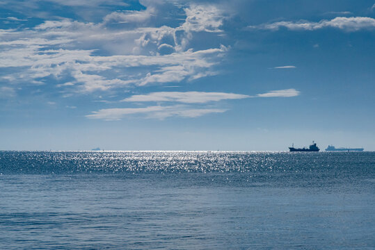 Calm blue ocean meeting a bright cloudy sky along the coast of Cilacap, Central Java, Indonesia