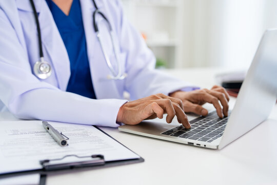 Electronic medical data. Close up doctor hand typing on laptop keyboard in medical office.