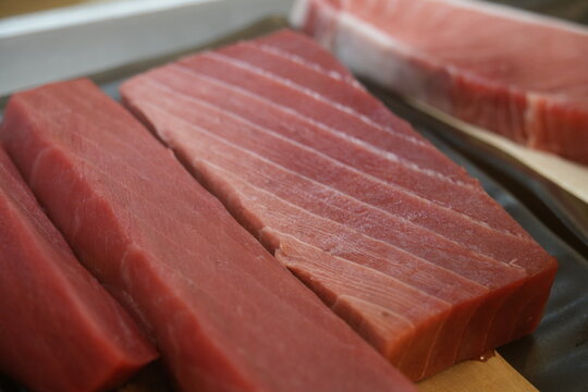 Fresh raw tuna blocks displayed closely in a market.