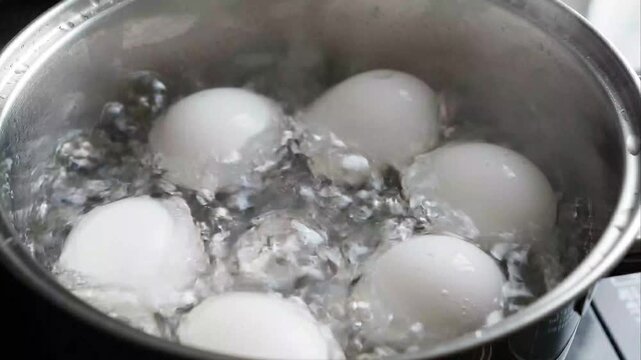 Eggs Boiling in Bubbling Hot Water Inside Clear Glass Pot on Stove