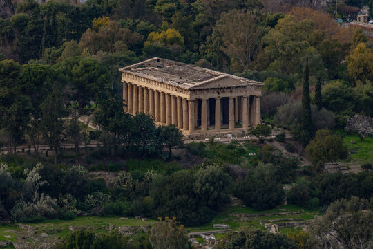Aerial view of the ancient Temple of Hephaestus, a remarkably preserved Doric peripteral temple, nestled within the lush greenery of the Ancient Agora of Athens, Greece.