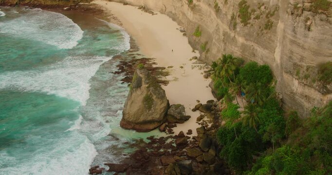 Wide view of secluded sandy beach with steep cliffs in Nusa Penida Bali Indonesia