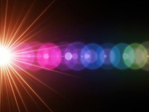 Bright light burst with rainbow color bokeh effect on black background.