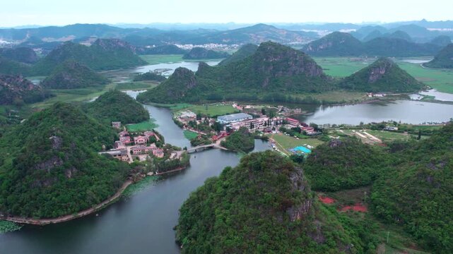 Aerial panorama of a karst landscape with waterways, villages, and green mountains in a southern China natural setting.