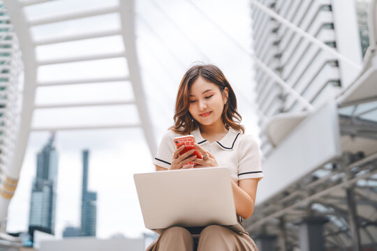 Business freelance young adult asian woman using laptop computer and cell phone