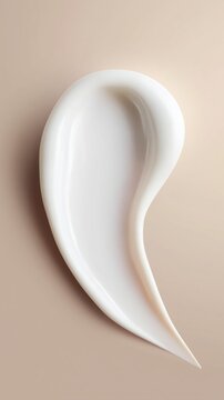 Close-up of a cosmetic cream stroke on a matte neutral surface. The soft, creamy texture exudes calm luxury and refined beauty style.