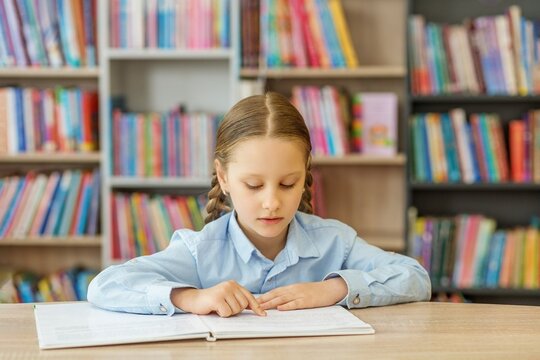 Schoolgirl Reading Book in Library