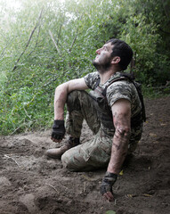 Naklejka premium Young soldier sitting on the ground