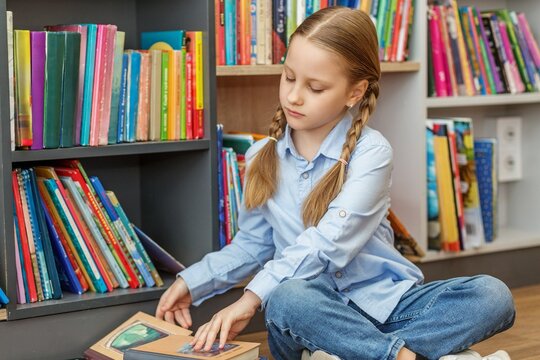 Schoolchild choosing book in library