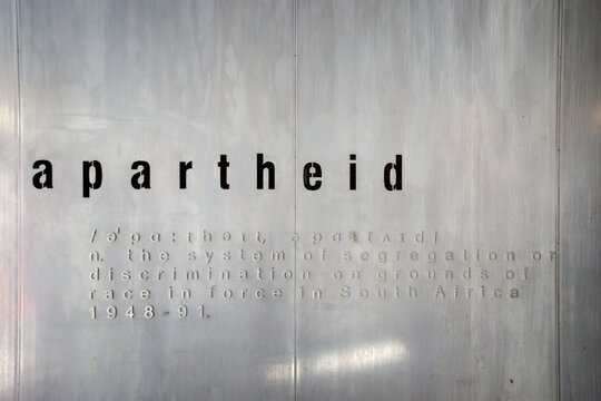 Johannesburg, South Africa - 15 May 2019 : Definition of Apartheid Etched on Concrete Wall Displaying Systemic Racial Segregation Text