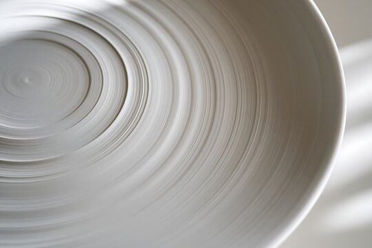 Minimalist white ceramic bowl with concentric circles pattern and shadows