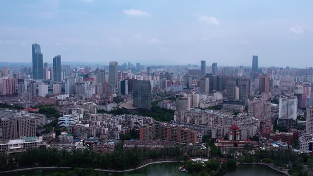 An elevated panoramic view of a dense urban city with mixed high-rise and mid-rise buildings under a clear sky.