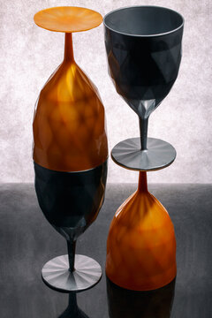 Four multicolored glasses stacked on top of each other on a gray background