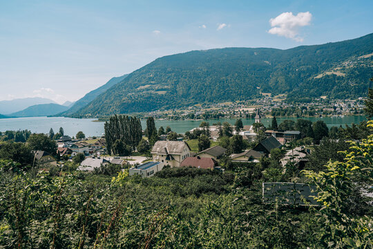 Ossiach, Austria - August 09, 2026: Scenic view of Ossiacher Tauern mountains overlooking a tranquil lake with charming houses and lush greenery in the foreground