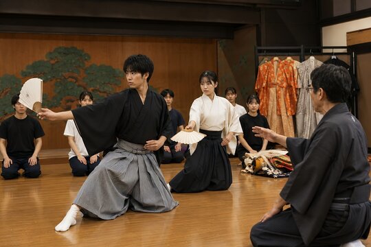 Young japanese students practicing traditional iaido sword techniques at dojo