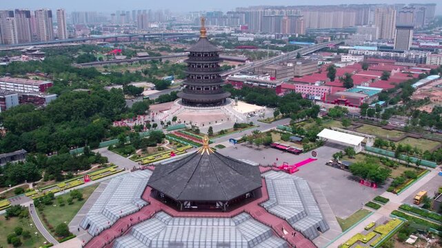 Aerial view of two traditional ancient buildings in an urban park, surrounded by city structures and greenery.