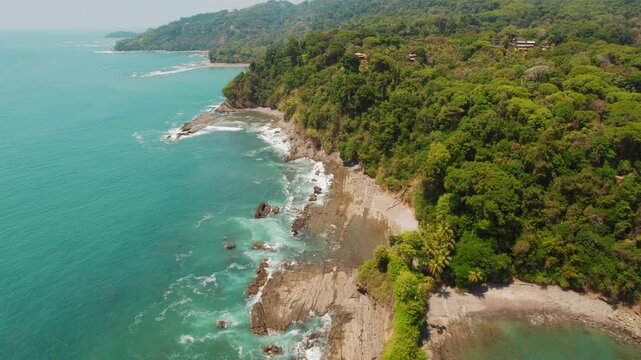 Tropical forest coastline with turquoise ocean on rocky shoreline