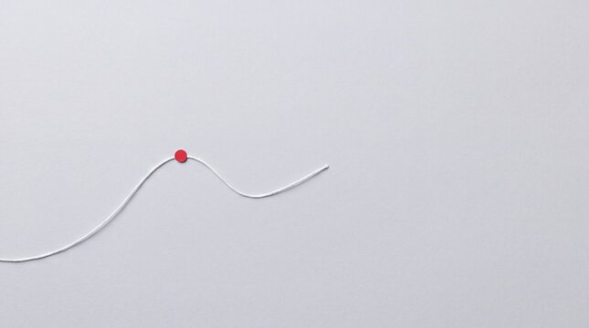 Minimalist white string with a single red bead, a simple abstract composition on a clean background, ideal for graphic design elements or conceptual imagery
