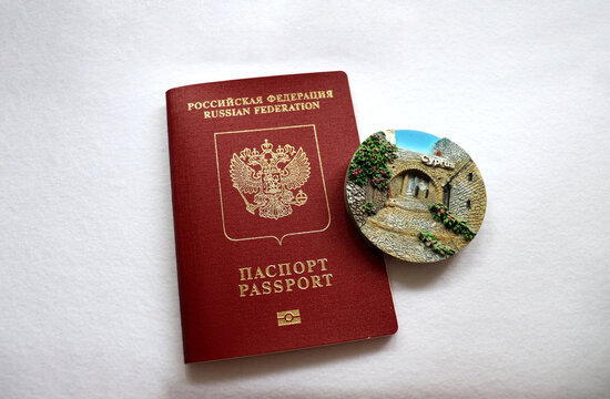 Moscow, Russia - 07.22.2026: A Russian passport and a Cypriot magnet on a white background. Concept of travel to Cyprus, tourist trip - horizontal photo, close-up