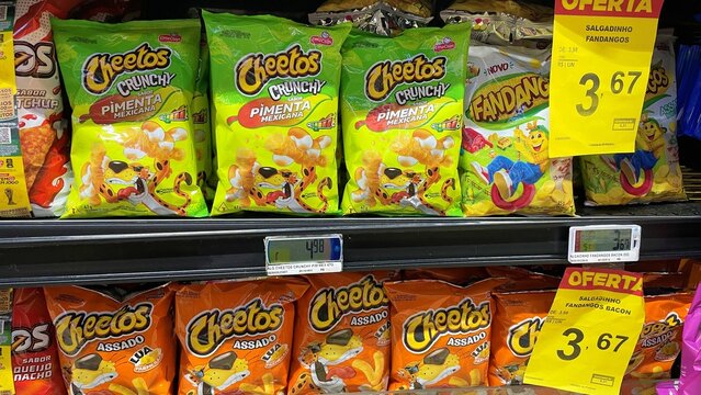 Salvador, Brazil - August 23, 2026: Packages of Cheetos and Fandangos snacks on display on a supermarket shelf. PepsiCo salty snack food products in Brazilian grocery retail.
