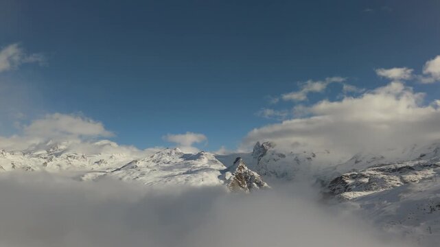 スイスアルプスの雪山を雲海の上から空撮、青空と峰々（Swiss Alps Snowy Peaks Above Sea of Clouds Aerial）