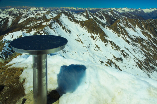 The Alps seen from the top of Corno Stella, a peak in the Orobie Alps. On the left a metal orientation table (also called toposcope or viewpoint indicator). Foppolo, Province of Bergamo, Italy