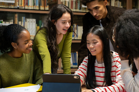 Diverse high school students collaborating and learning together in a university library