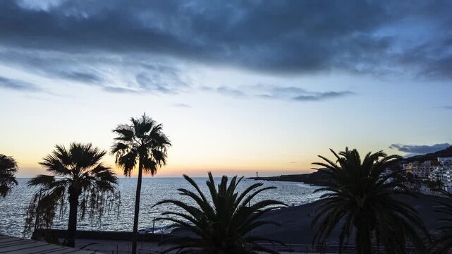 Puerto Naos dusk motion lapse panning beach resort palm tree silhouettes La Palma Spain