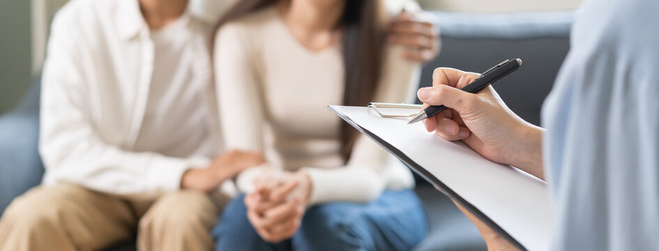 Psychology, depression asian young couple love woman and male patient consulting problem mental health with psychologist, psychiatrist at clinic together, wife encouraging husband, therapy health care