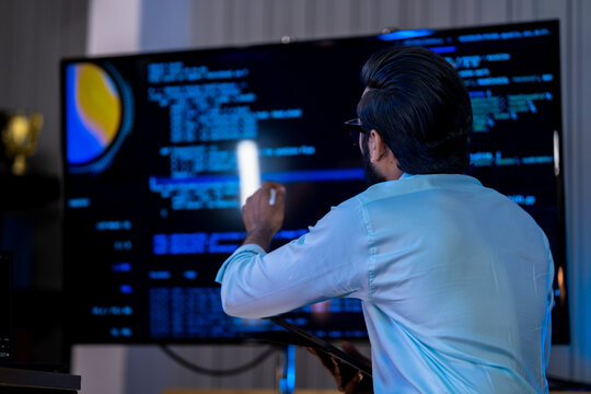 Technical expert visualizing algorithmic data patterns and machine learning datasets using tablet-based digital modeling tools in a tech hub.