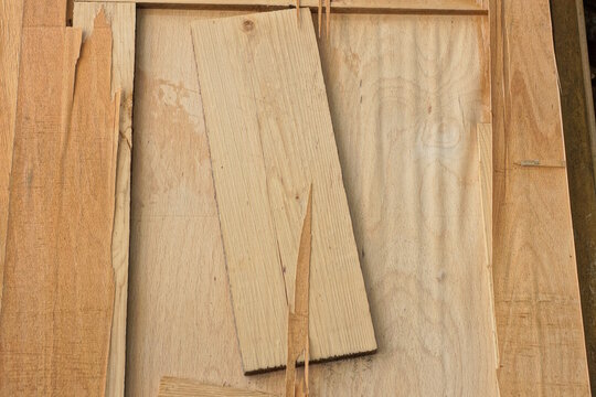 wood texture from a piece of old brown dirty worn and cracks plywood in a wall