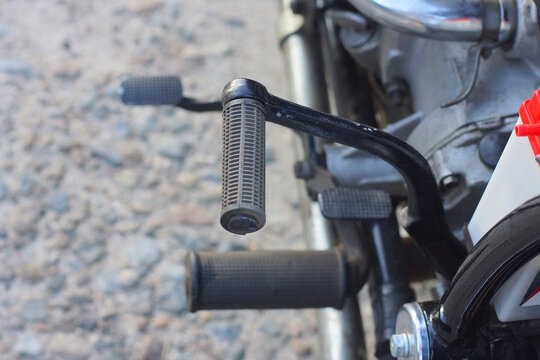 One black plastic metal footrest on a motorcycle on a summer street