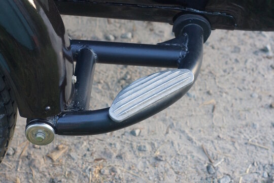 One black plastic metal footrest on a motorcycle on a summer street